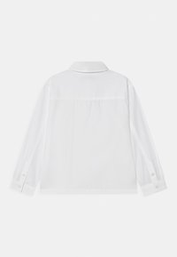 Biała koszula z długim rękawem, z kołnierzykiem i gładką teksturą materiału. Z tyłu znajduje się karczek bez dodatkowych detali.