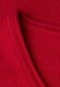 Maglione rosso lavorato a maglia con una trama a coste e una finitura liscia e morbida. Presenta un scollo a V e lievi variazioni nella densità del tessuto.