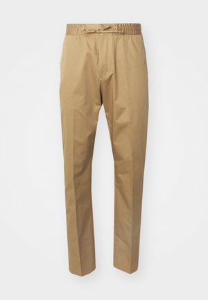 Pantalon beige avec une taille élastique et un cordon de serrage réglable. Texture lisse, jambes droites et design minimaliste.