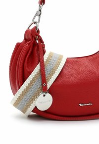 Rode leren handtas met een gestructureerde afwerking, voorzien van een gevlochten schouderriem in beige, grijs en wit, met een metalen logo charm eraan bevestigd.