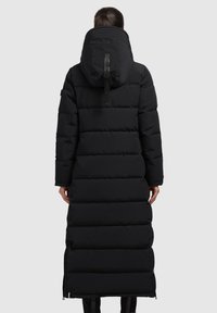 Palton lung negru tip puffer, cu un design căptușit, glugă și fermoare pe laterale. Materialul pare neted și impermeabil, având un aspect elegant și minimalist.