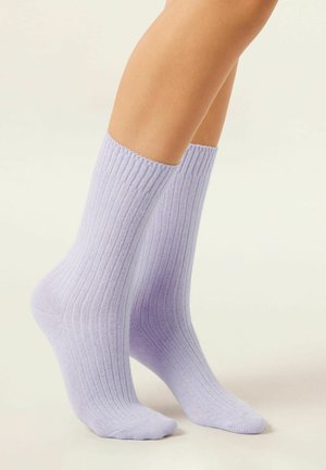 Chaussettes rayées lilas, de hauteur moyenne, avec une texture douce, un bord supérieur serré et une couture de orteil lisse. Convient pour une tenue décontractée.