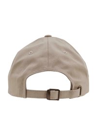 Gorra de béisbol de algodón beige con visera curva, que cuenta con una correa de tela con una hebilla de metal en la parte trasera y ojales de ventilación.