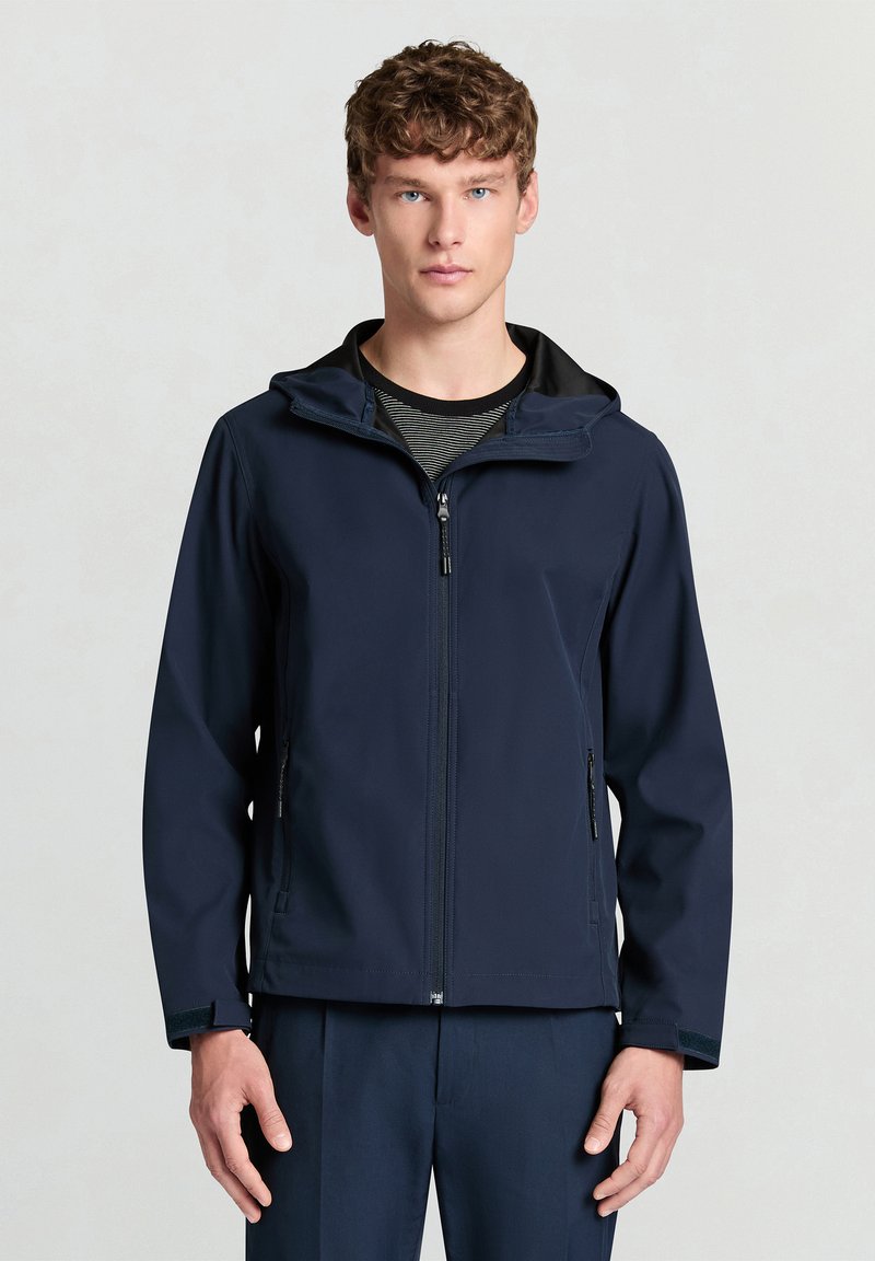 Marineblaue, wasserabweisende Jacke mit durchgehendem Reißverschluss, verstellbarer Kapuze und Seitentaschen. Glatte Textur, leicht und mit tailliertem Schnitt.