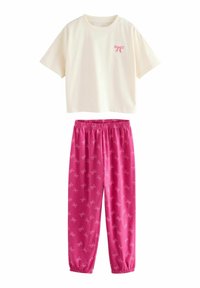 Camicia bianca a maniche corte con piccolo motivo a fiocco rosa, abbinata a pantaloni rosa con elasticità in vita, caratterizzati da un motivo a fiocchi rosa chiaro.