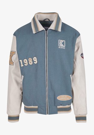 Zila un krēmkrāsas sporta jakas ar rāvējslēdzēju priekšā, ribinātu apkakli un aprocēm. Uzsāktā "KANI" emblēma, izšūta 1989. gadā, un Brooklyn, NYC detaļas.