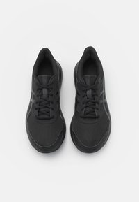 Baskets de sport noires avec tissu en maille, fermeture à lacets, surface texturée et accents réfléchissants sur les côtés. Bout rond et semelle rembourrée.