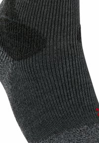 Chaussette côtelée gris foncé en tissu texturé avec un talon renforcé. Présente une petite touche de rouge près des orteils.