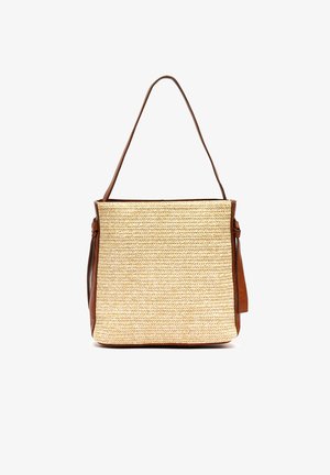 Bolso rectangular de paja tejida con laterales de cuero marrón, una única correa para el hombro y una pequeña etiqueta de cuero en el lado derecho.
