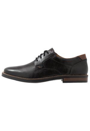 Black leather dress shoe with a smooth texture, round toe, lace-up design, and a contrasting brown heel accent. Stitched detailing on the sole.