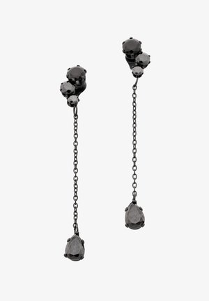 Zwarte metalen hangende oorbellen met drie ronde stenen bovenaan en een druppelvormige steen die aan een dunne ketting hangt.