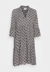 Robe à motifs noir et blanc avec un col à volants, des manches évasées et une jupe à étages présentant un motif en éventail.
