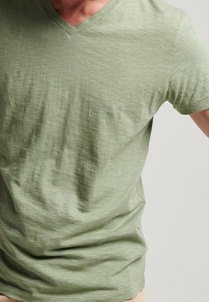 Lys grøn v-hals t-shirt lavet af et blødt, tekstureret stof. Kortærmet og med en afslappet pasform, velegnet til afslappet brug. Ingen synlige mønstre.