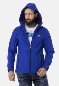 Blaues Softshell-Jacke mit Kapuze, Reißverschluss vorne und Taschen, ausgestattet mit schwarzen Reißverschlüssen und einem schlanken, aerodynamischen Design.