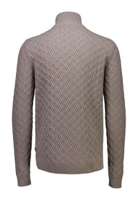 Beige gebreide trui met een ruitpatroon, hoge kraag en rib gebreide mouwen en onderkant. De gebreide structuur voegt diepte toe aan het ontwerp.