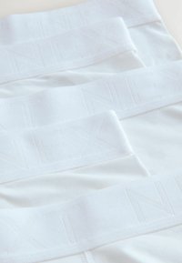 Witte onderkleding met een gestructureerde stof, voorzien van een bijpassende witte elastische tailleband met een subtiel reliëf van "NEXT".