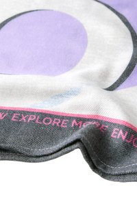 Barevná látka s velkým purpurovým kruhem na světlém pozadí, s růžovým a šedým okrajem, který obsahuje text a detaily dokončení.
