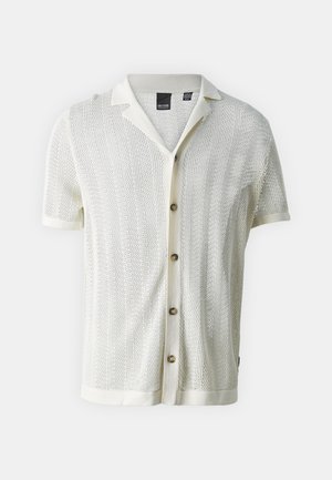 Maglietta a maniche corte in maglia color avorio con un motivo testurizzato, design con colletto, cinque bottoni marroni e polsini arrotolati.