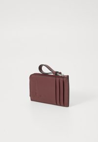 Portafoglio in pelle bordeaux con chiusura a zip, diverse fessure per carte su un lato e un anello per attacco, caratterizzato da una superficie liscia.