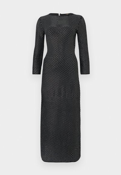 Abito lungo nero a maniche lunghe con scollo rotondo, caratterizzato da un motivo a pois bianchi in tutto il capo e una cerniera nascosta sul retro.