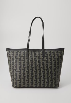 Svart totebag laget av teksturert materiale, med et geometrisk mønster i lys kremfarge. Lange, flate håndtak for enkel bæring.