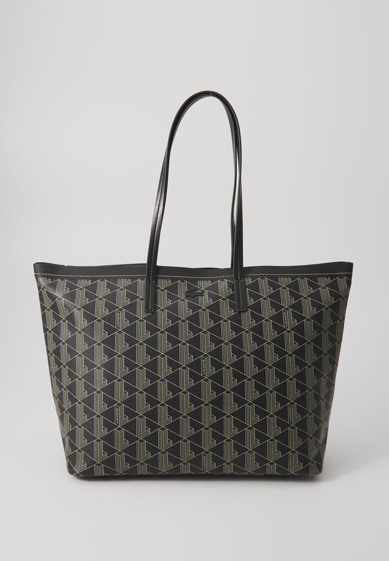 Saco tote preto feito de material texturizado, apresentando um padrão geométrico em creme claro. Alças longas e planas para transporte fácil.