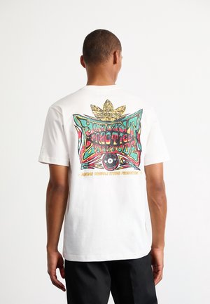 Mann trägt weißes Adidas T-Shirt mit buntem Graffiti-Stil-Design, Text "Student Practice Attitude," und Adidas-Logo auf der Rückseite.