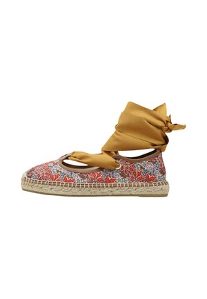 Alpargata plana floral con flores rojas y azules, suela trenzada beige, y cinta amarilla mostaza para el tobillo atada con un lazo.