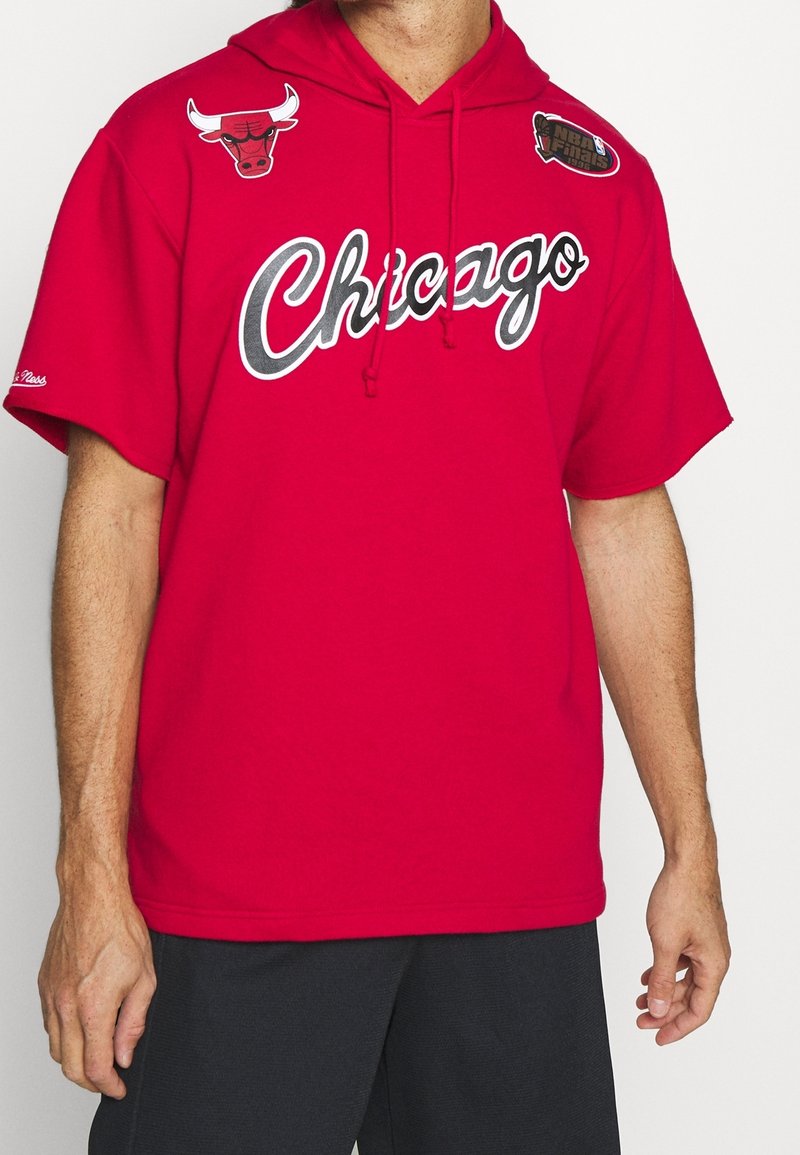 Sudadera con capucha roja con "Chicago" en texto blanco, presentando logotipos del equipo en negro y rojo en los hombros. Fabricada con una tela suave y casual.