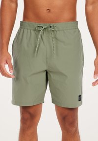 Olijfgroene zwemshorts gemaakt van lichtgewicht materiaal, met een elastische tailleband met trekkoord en een klein logo-opdruk aan de zijkant.