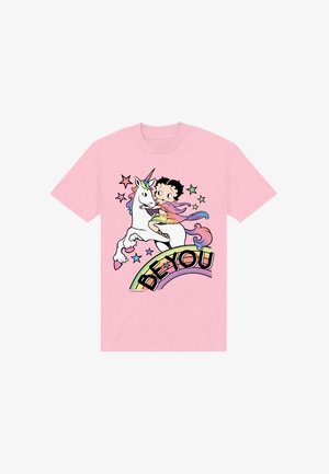 Różowa koszulka z rysunkową postacią jadącą na białym jednorożcu, otoczona kolorowymi gwiazdkami i tęczą z napisem "BĄDŹ SOBĄ."