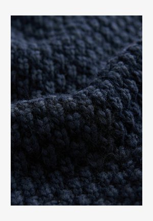 Tume sinine kootud kangas tekstuurse pinna ja tükiliste koobitustega, pehmete ja uduste kiududega. Pole tajutavaid mustreid ega aktsente.