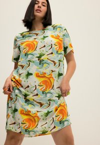 Lyhythihainen mekko, joka on valmistettu kevyestä kankaasta ja jossa on värikäs abstrakti kuvio oranssilla, vihreällä ja sinisellä. Mekossa on rento malli.
