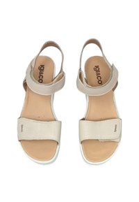 Sandali in pelle beige con fasce larghe, retro regolabile e suole bianche. Dettaglio logo notevole sulla fascia. Design piatto e con punta aperta.