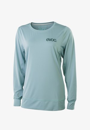Hellblaues langärmeliges Sportshirt mit Rundhalsausschnitt, eng anliegenden Bündchen und "evoc" Logo auf der linken Brust.