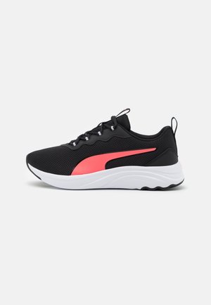 Czarny sportowy sneaker z białą podeszwą i różowym paskiem po boku, siateczkowa faktura, sznurowane zapięcie oraz uchwyt przy pięcie, pokazany z boku.