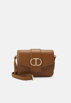 Sac bandoulière en cuir marron avec boucle ovale dorée et sangle réglable sur fond blanc.