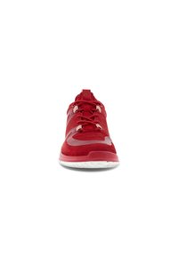 Chaussure de sport rouge avec lacets, semelle blanche tachetée et un design incurvé translucide à l’orteil, vue de face.