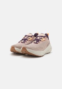 Lys rosa joggesko med sikksakk-mønstrete overdel, mørkelilla snøring og oransje detaljer på hælen. Tykk beige såle for demping.