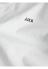 Biela bavlnená tričko s malým čiernym logom "JJXX" na prednej strane, so hladkou textúrou a štandardným dizajnom s okrúhlym výstrihom.