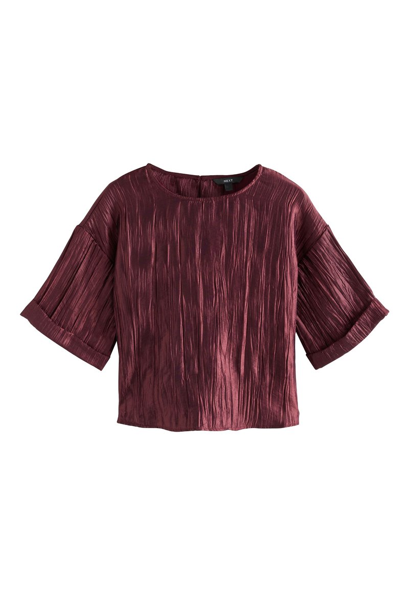Haut bordeaux à manches courtes avec un design texturé plissé et un col rond. Comprend de larges manches et une coupe décontractée.