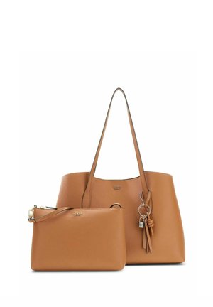 Deux sacs en cuir marron clair Guess, un grand cabas avec double anses et porte-clés pompon, et une petite pochette détachable avec fermeture éclair.