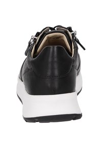 Schwarze Ledersneaker mit einer weißen Gummisohle, ausgestattet mit einem strukturierten Obermaterial und dekorativen Reißverschlüssen an der Rückseite. Minimalistisches Design.