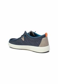 Zapato sin cordones de lona navy con acentos sintéticos grises, suela blanca y lengüeta naranja en el talón. Forro de malla para transpirabilidad.