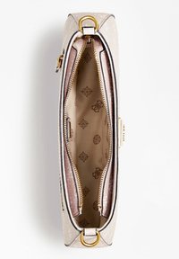 Světle béžová vzorovaná kabelka viděná shora, s otevřeným zipem odhalujícím béžovou podšívku s jemnými potisky emblémů.