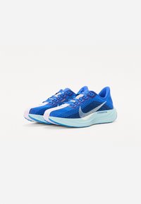Blaue Sportschuhe mit einem atmungsaktiven Mesh-Obermaterial, strukturiertem Design, silbernem Swoosh-Logo und einer Farbverlauf-Mittelsohle, die von Hellblau zu Türkis übergeht.