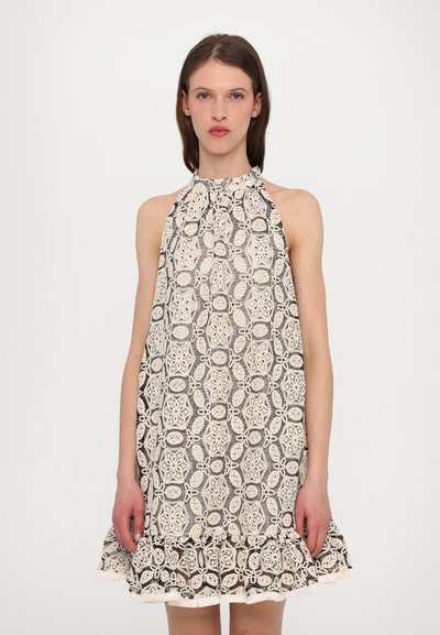 Robe sans manches avec un motif en dentelle noir et crème, ourlet à volants et col montant, présentant un tissu texturé et une coupe ample.