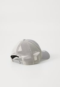 Casquette grise avec un panneau avant solide et un dos en mesh, dotée d'une sangle ajustable. La visière est légèrement courbée avec une finition texturée.