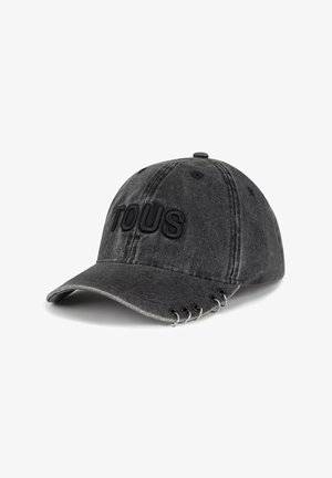 Gorra de béisbol negra lavada con "TOUS" bordado en la parte delantera y cinco anillos plateados unidos a lo largo del borde de la visera.