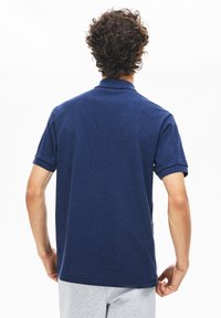 Marinblå pikétröja med strukturerad tyg, korta ärmar och klassisk krage. Designad med en vanlig passform och rakt avslut.